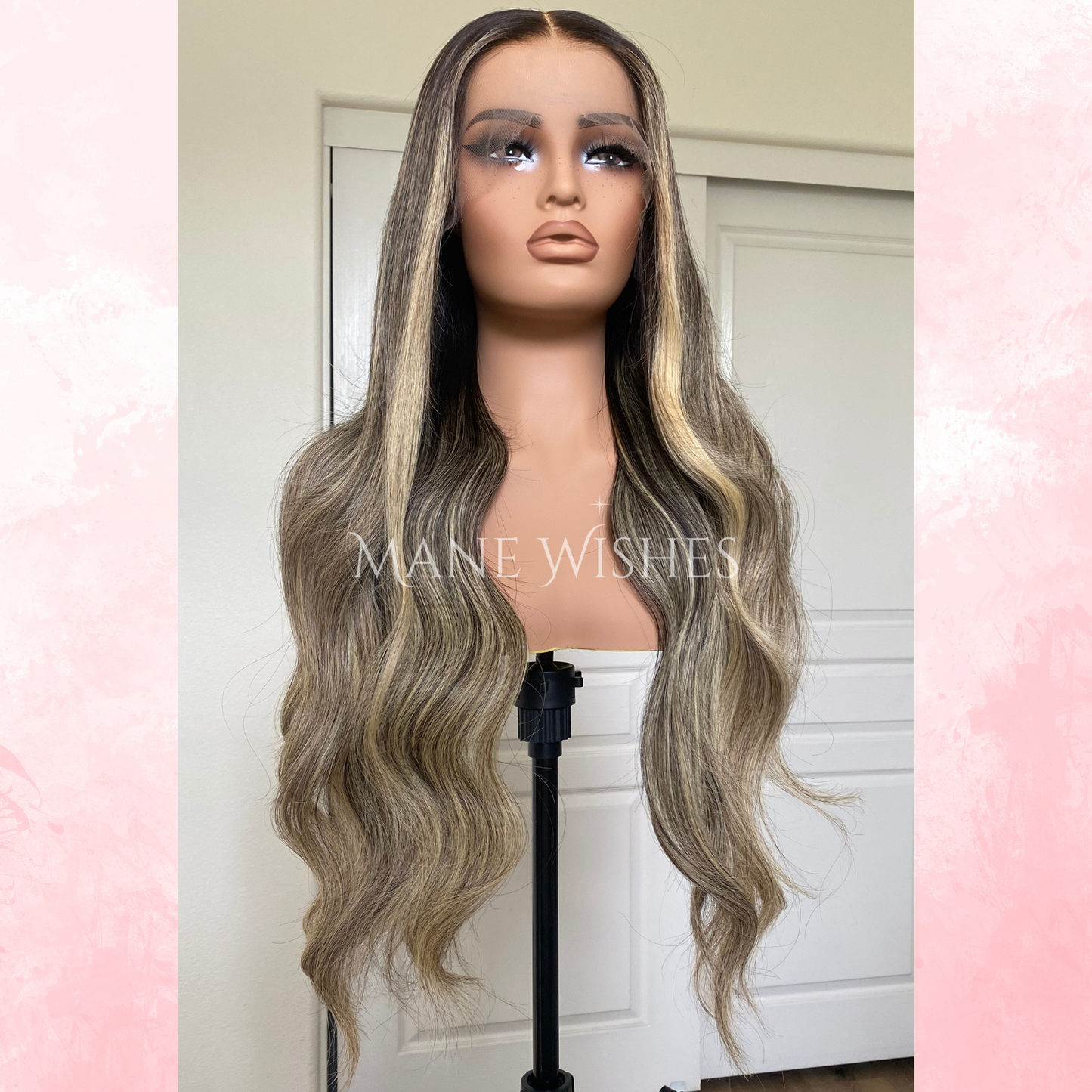 Mannequin head with long, wavy, gray and blonde wig on a stand against a white door background.