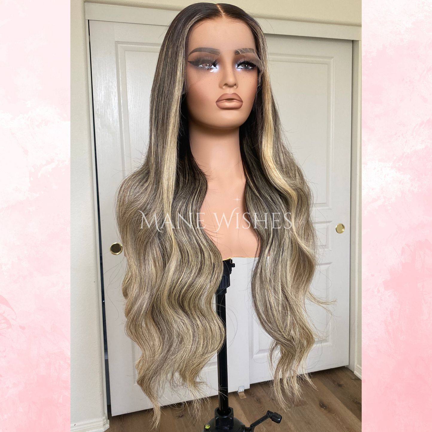 Mannequin head with long, wavy blonde wig on a stand against a white door background.