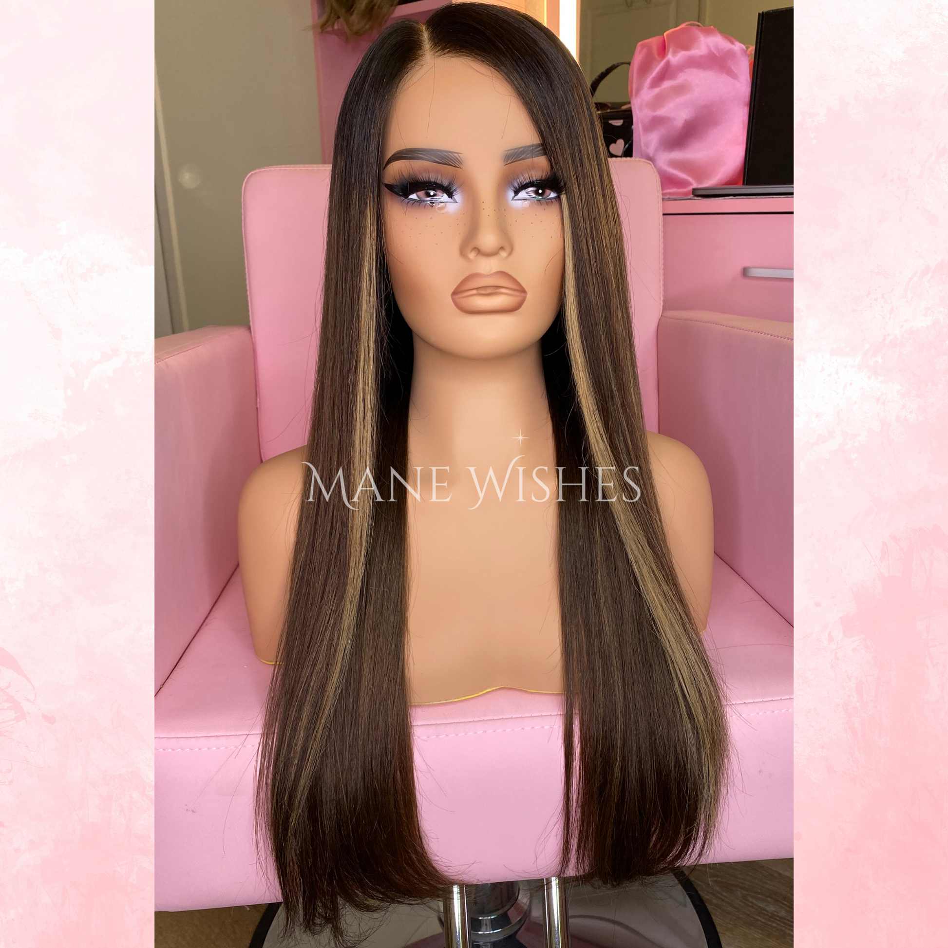 Mannequin head with a long brown wig on a pink chair, branded 'Mane Wishes'.