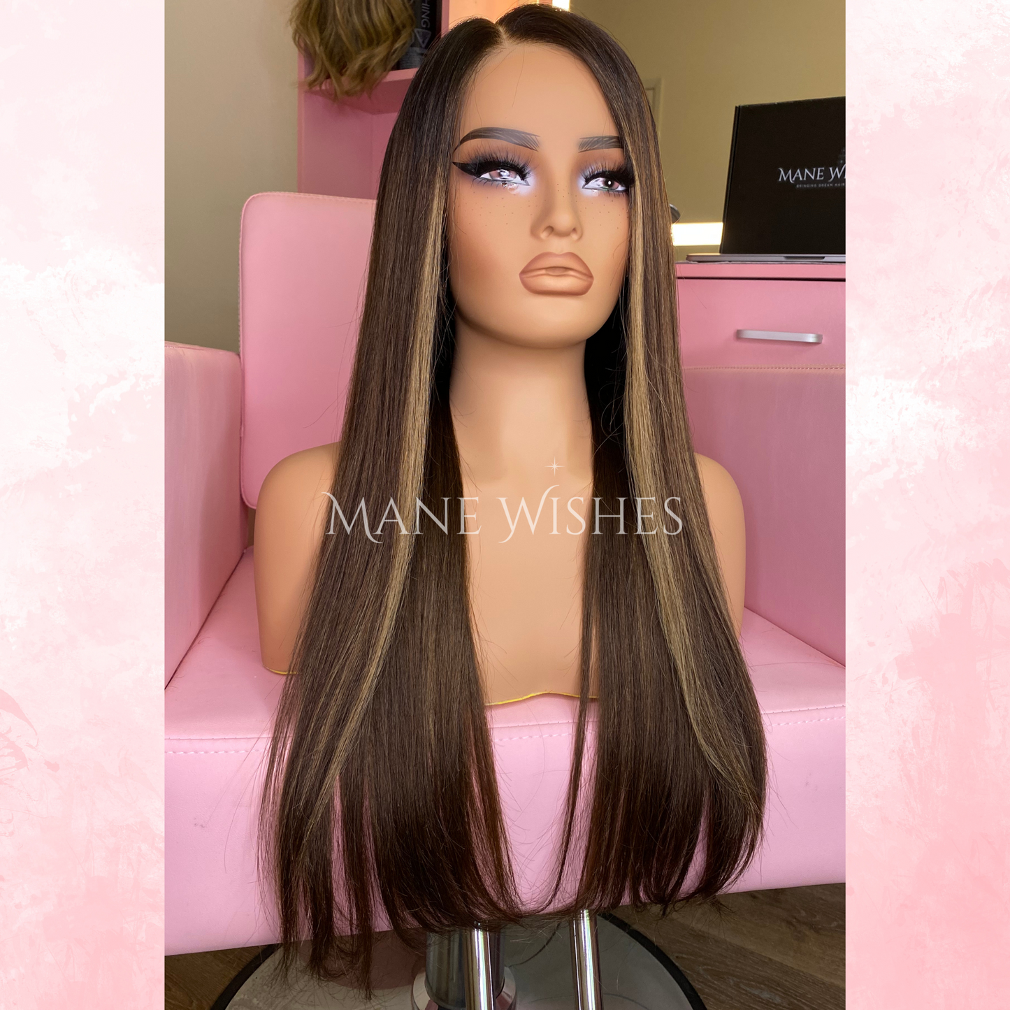 Mannequin head with a long brown wig on a pink chair, branded 'Mane Wishes'.