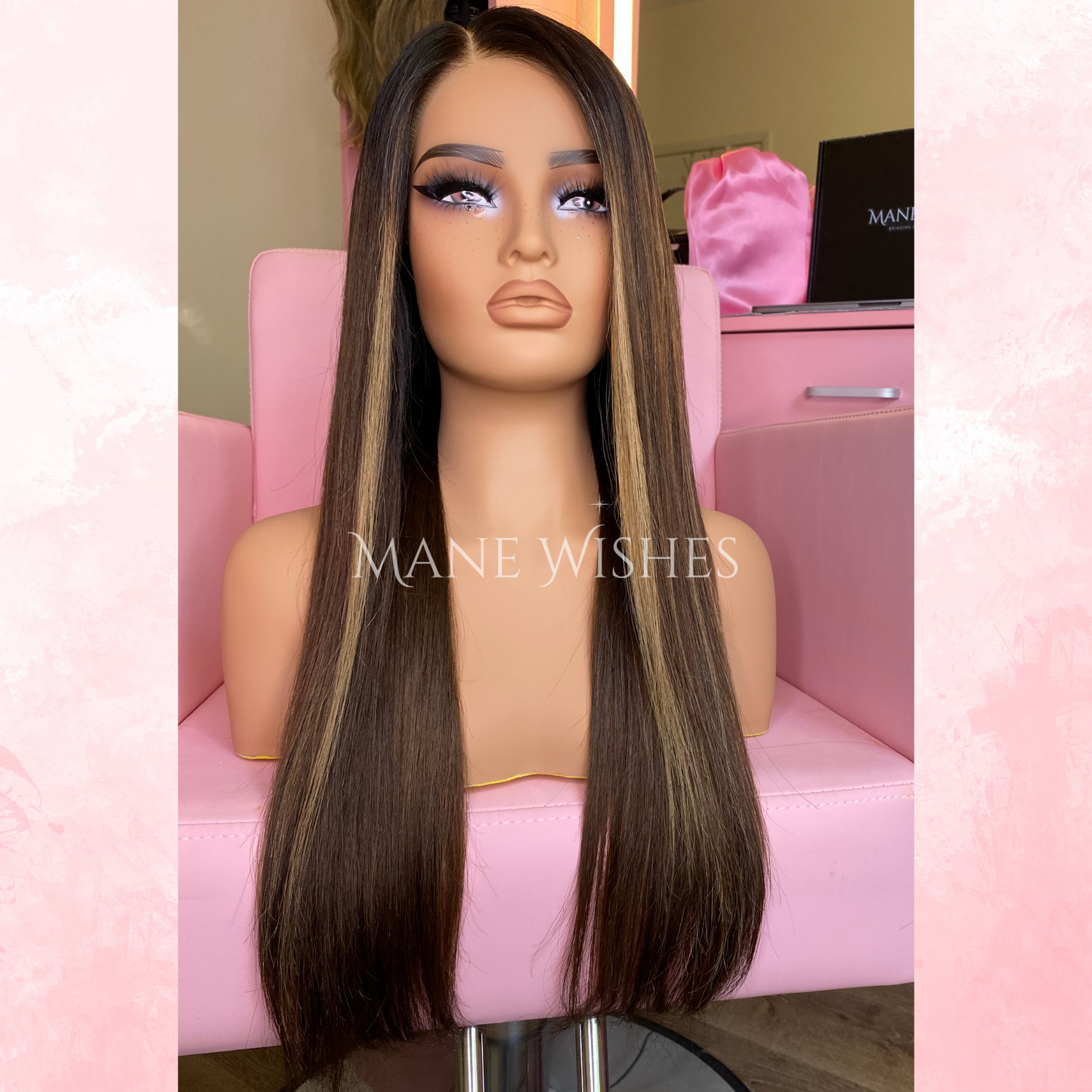 Mannequin head with long brown wig on a pink chair, branded 'Mane Wishes'.