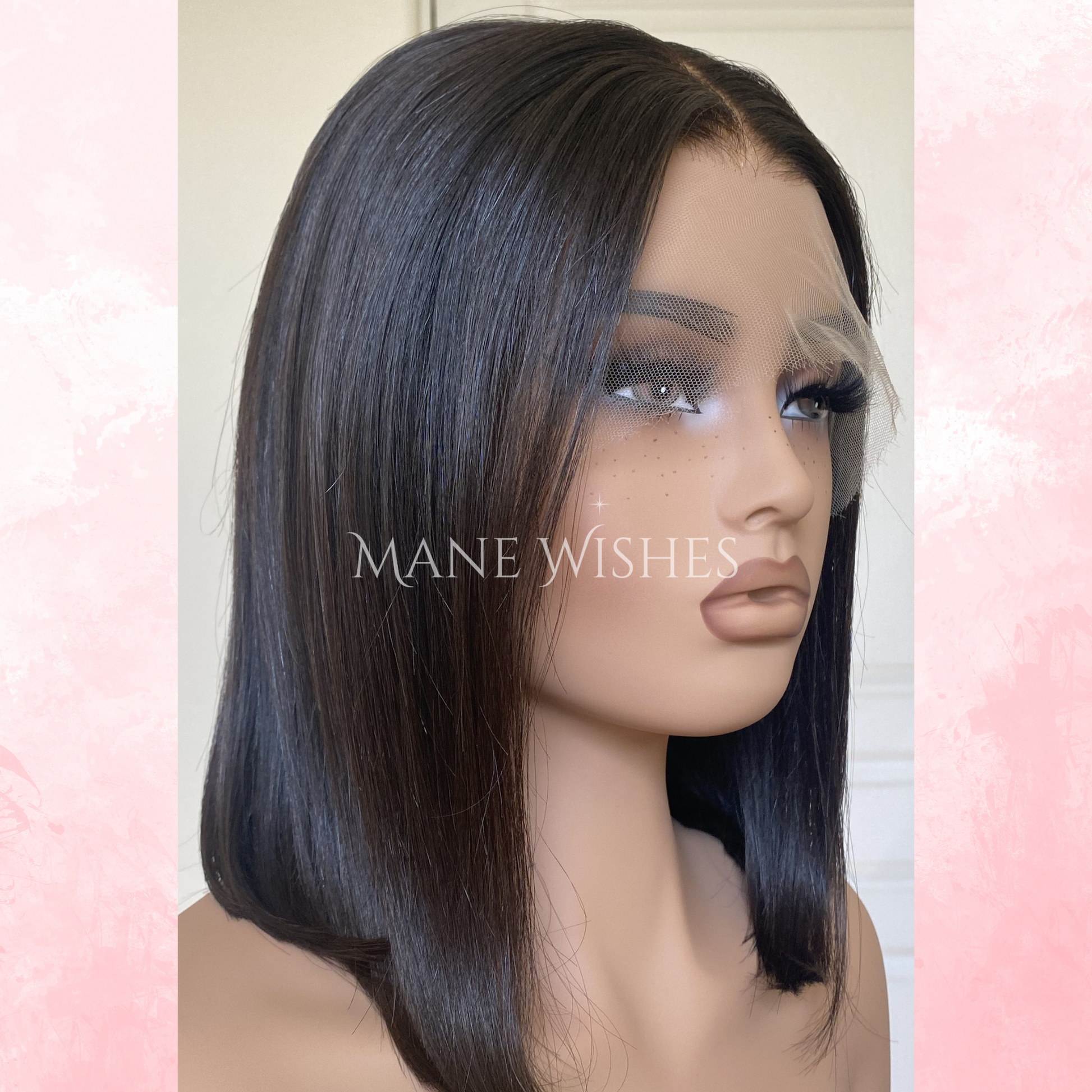 Mannequin head with a black wig on a pink and white background, featuring the brand 'Mane Wishes'.