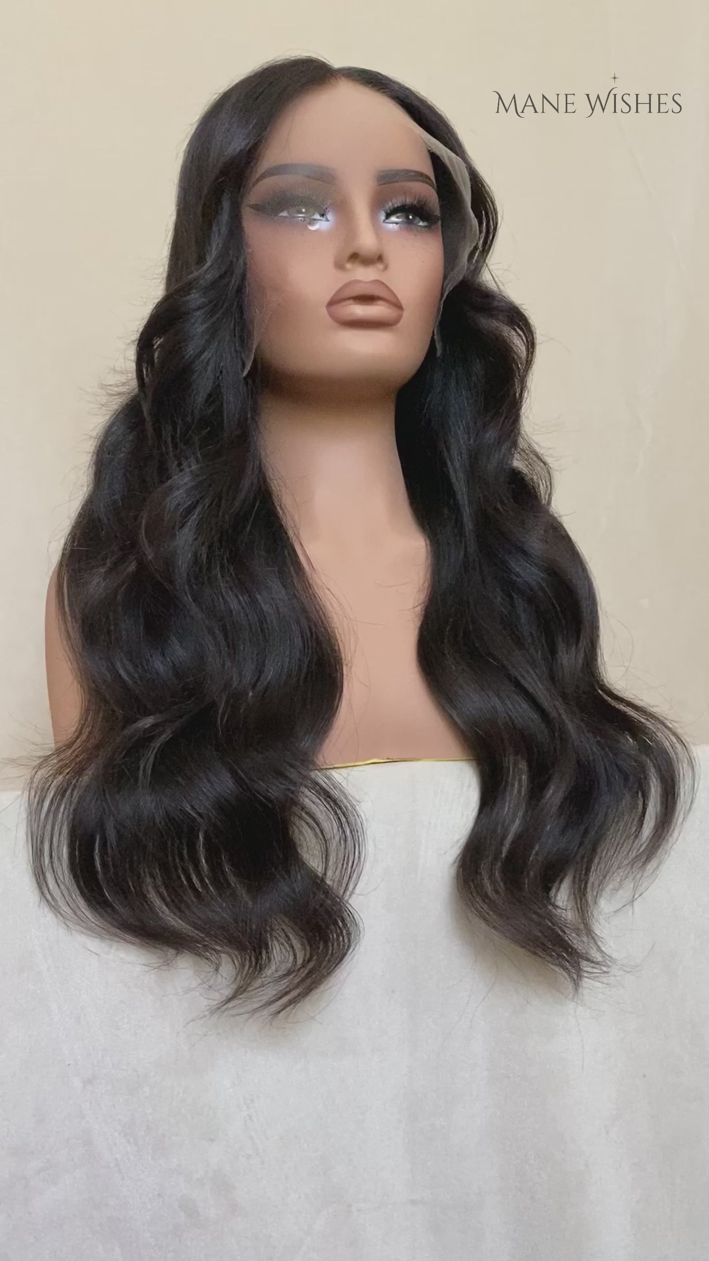 Mannequin head with long black wavy hair on a white background, branded 'Mane Wishes'.