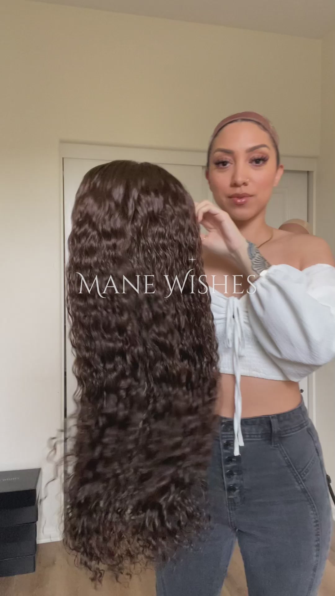Curly hair extension with 'Mane Wishes' branding against a neutral background