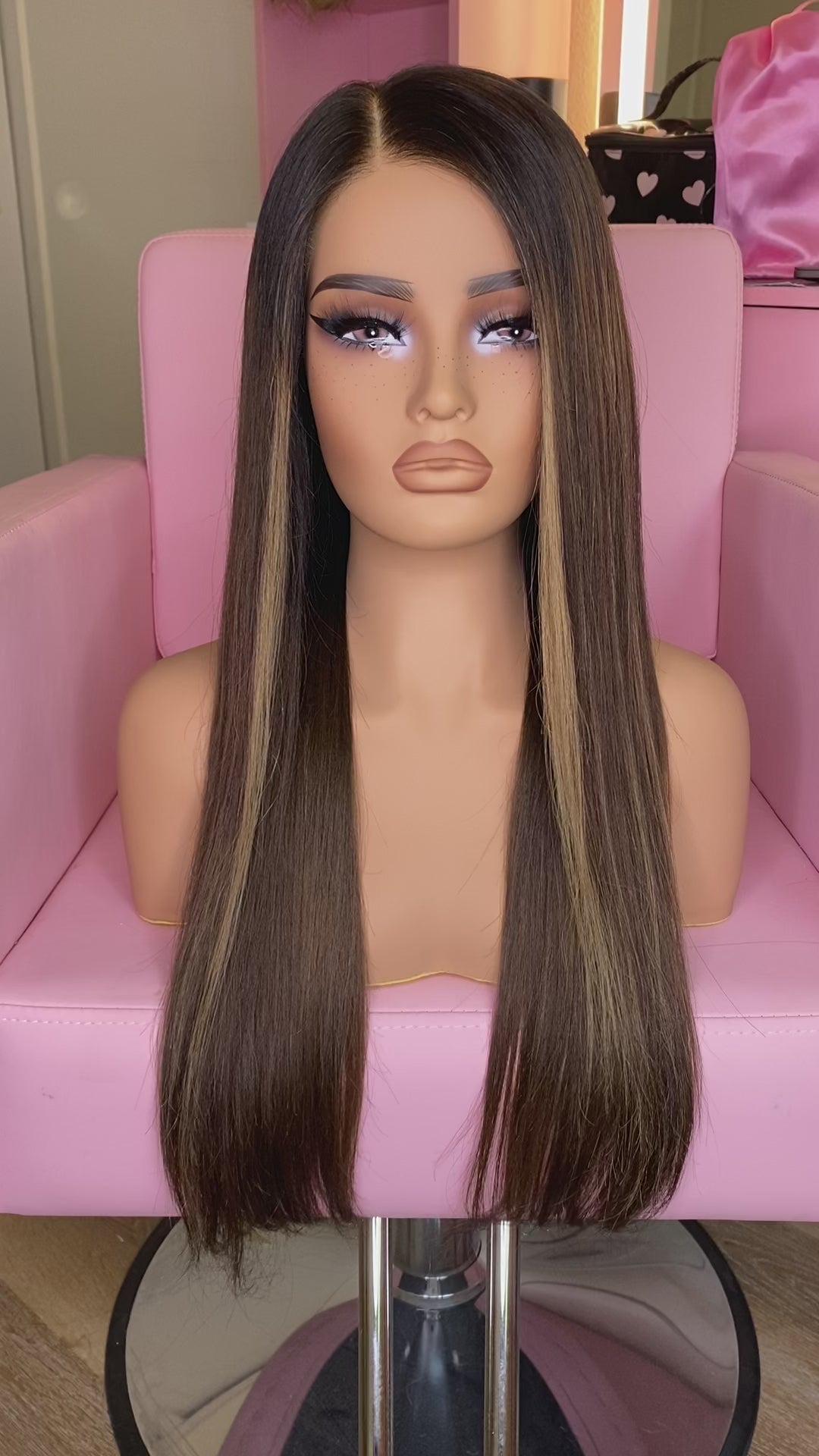 Mannequin head with long brown wig on a pink chair, branded 'Mane Wishes'.