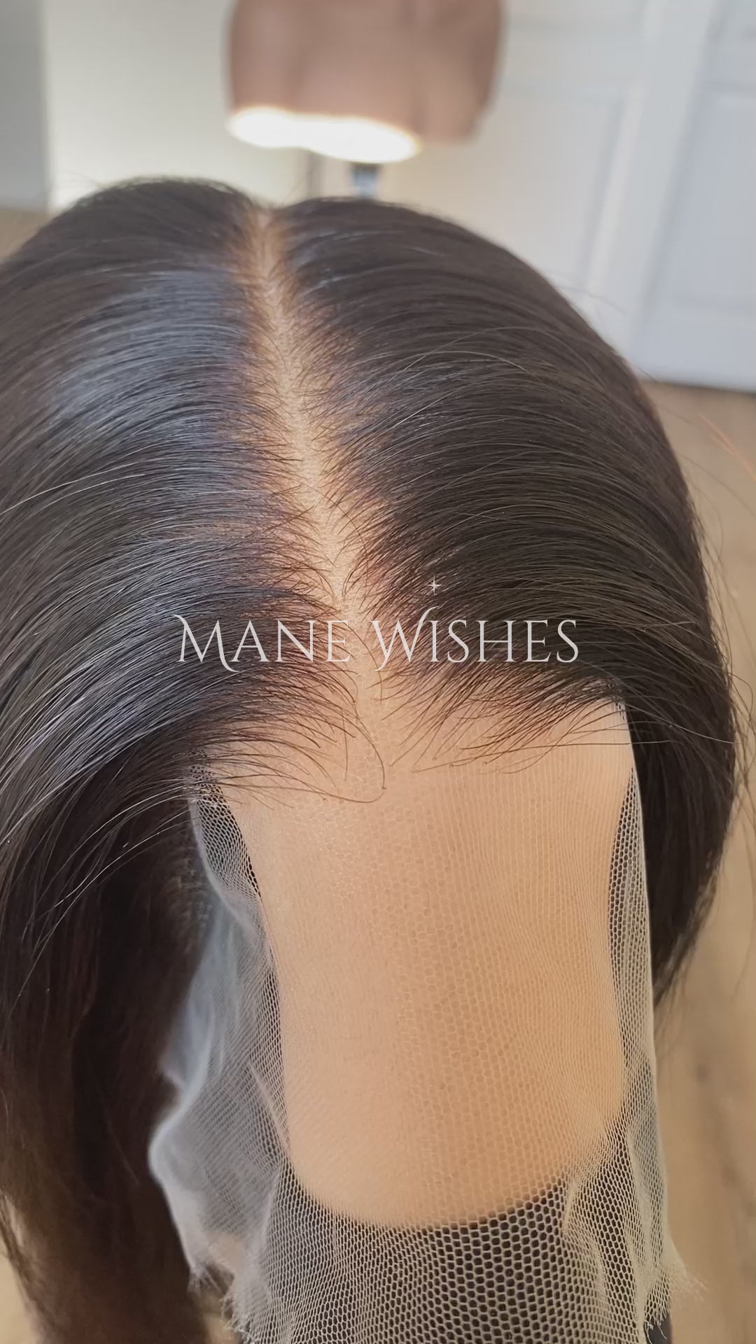 Mannequin head with a black wig on a pink and white background, featuring the brand 'Mane Wishes'.