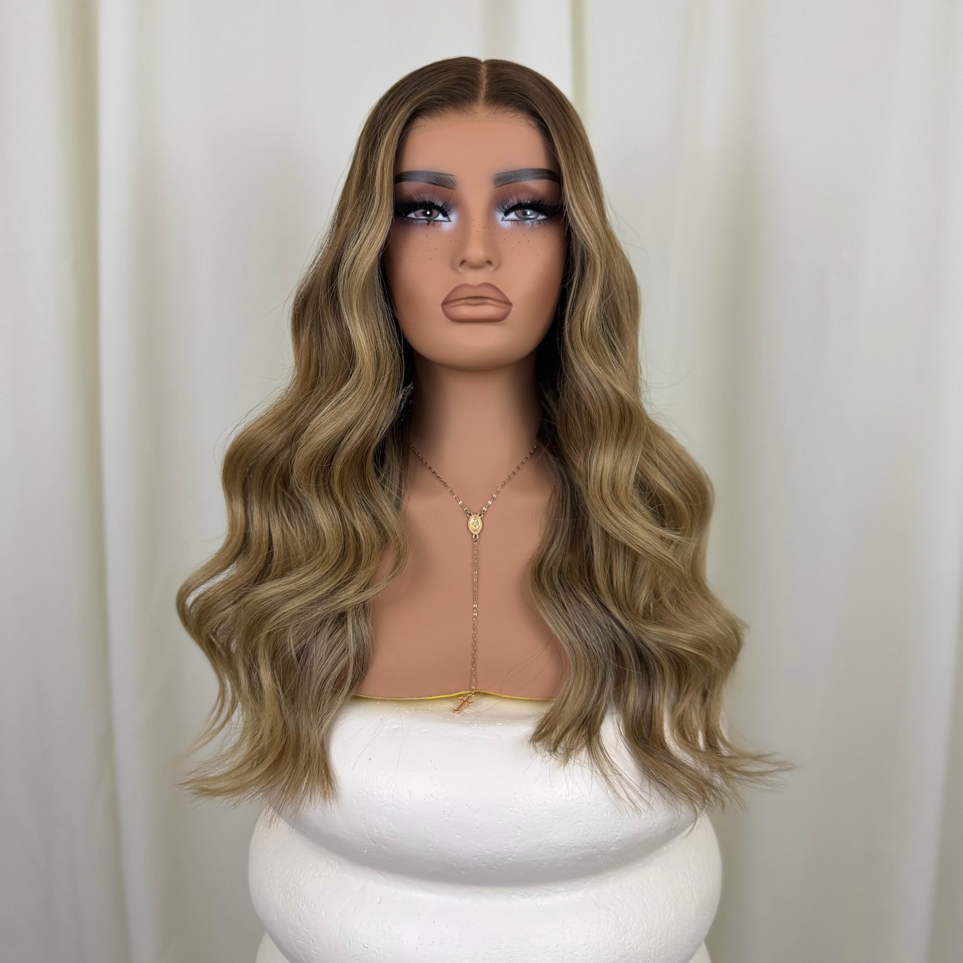 Mannequin head with a blonde wig on a plain background