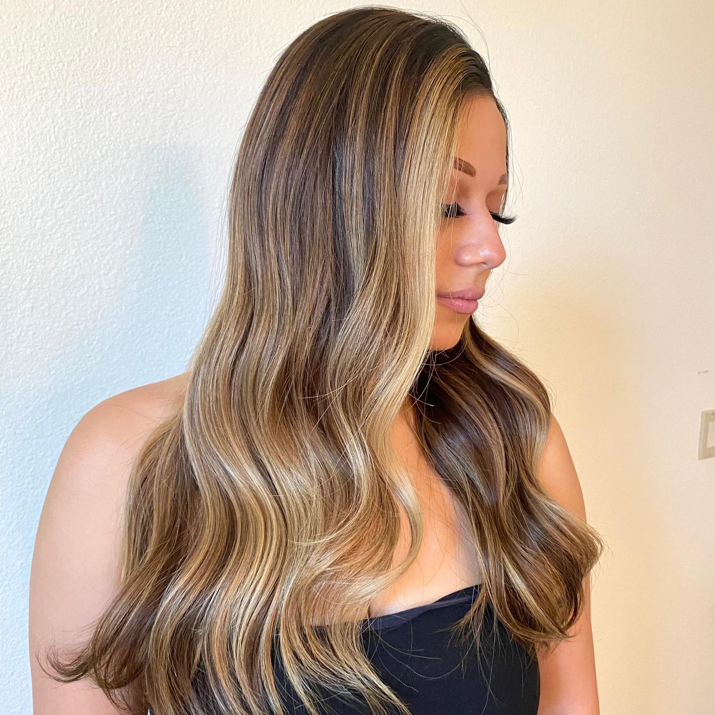 Woman with long, wavy hair in a neutral setting