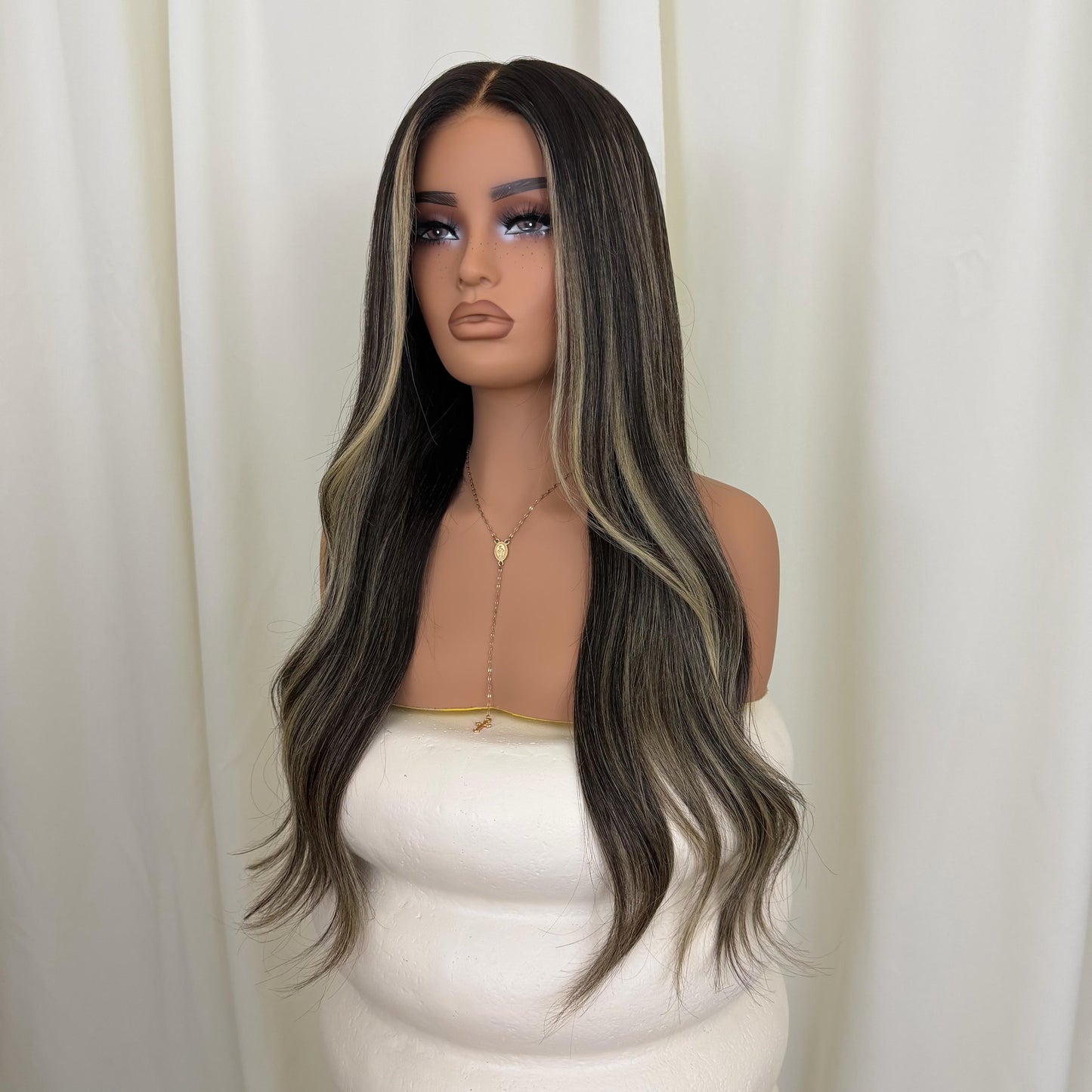 Mannequin head with a long, wavy wig featuring black to blonde ombre on a white background.