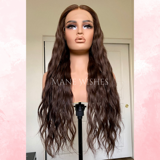 Mannequin head with long brown wig on a stand, branded 'Mane Wishes'.