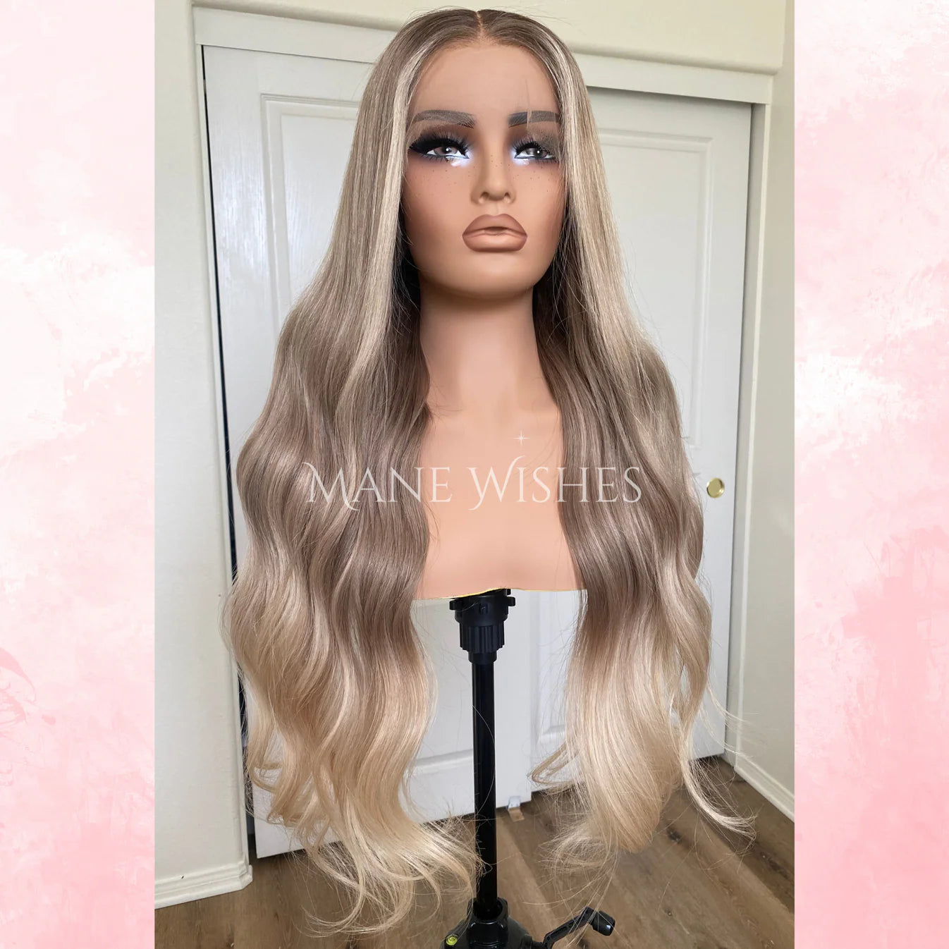 Blonde wig on a mannequin head with 'MAINE WISHES' branding against a neutral background.