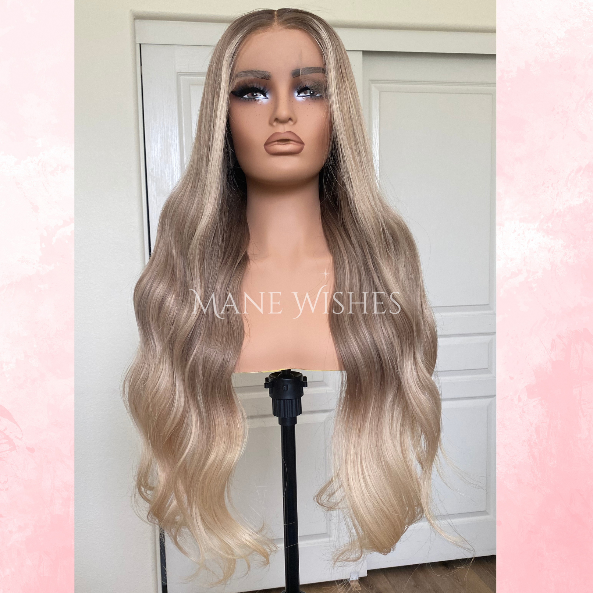 Blonde wig on a mannequin head with 'Mane Wishes' branding against a white door background.