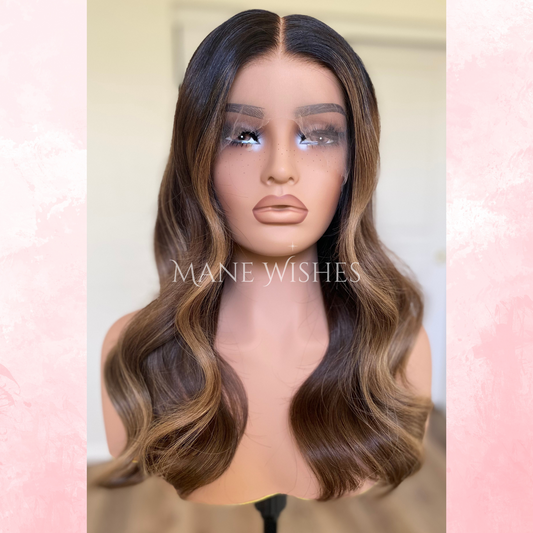 Mannequin head with brown wavy wig on a blurred background with 'Mane Wishes' branding.
