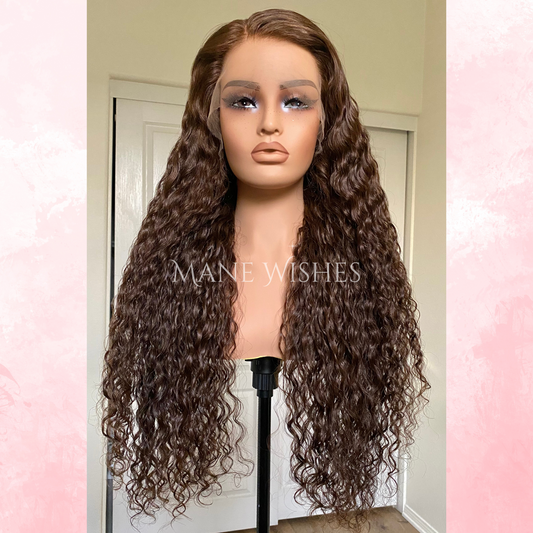 Mannequin head with long, wavy brown hair on a stand, branded 'Maine Wishes'.