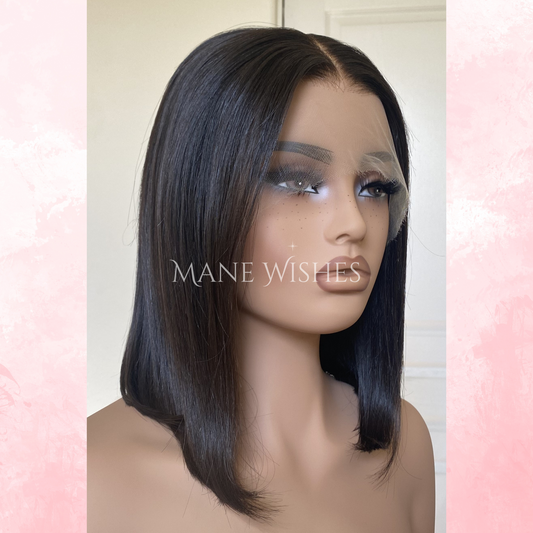 Mannequin head with a black wig on a light pink and white background, featuring the brand 'Mane Wishes'.