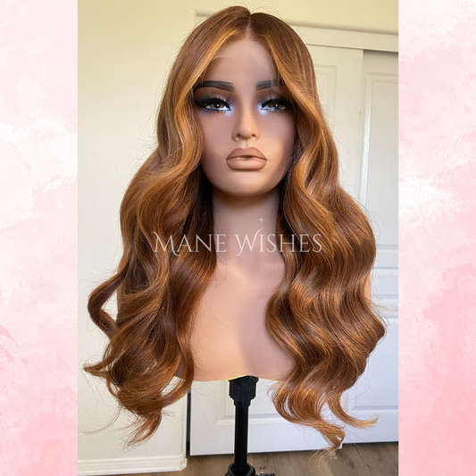 Mannequin head with wavy brown hair on a stand, branded 'Mane Wishes'.